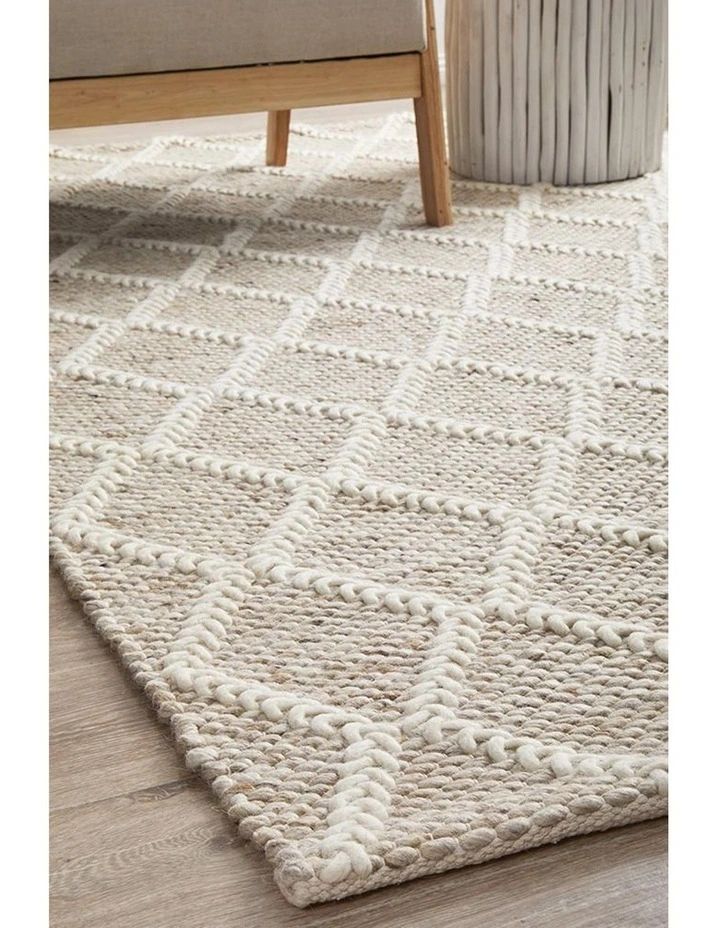 a white rug is on the floor next to a chair