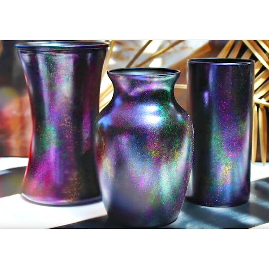 three shiny vases sitting on top of a table