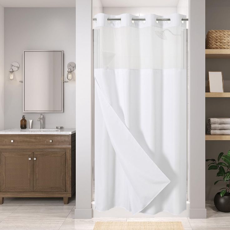 a white shower curtain in a bathroom next to a sink and mirror with shelves on either side