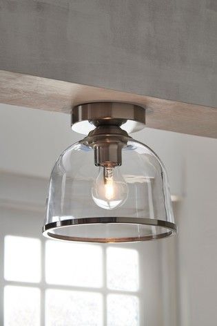 a clear glass light fixture hanging from a wooden beam in a room with white walls