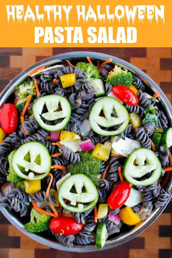 a bowl filled with pasta, vegetables and jack - o'- lanterns carved into faces