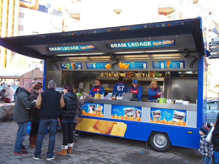 people are standing in line to get food from the ice cream truck that sells them