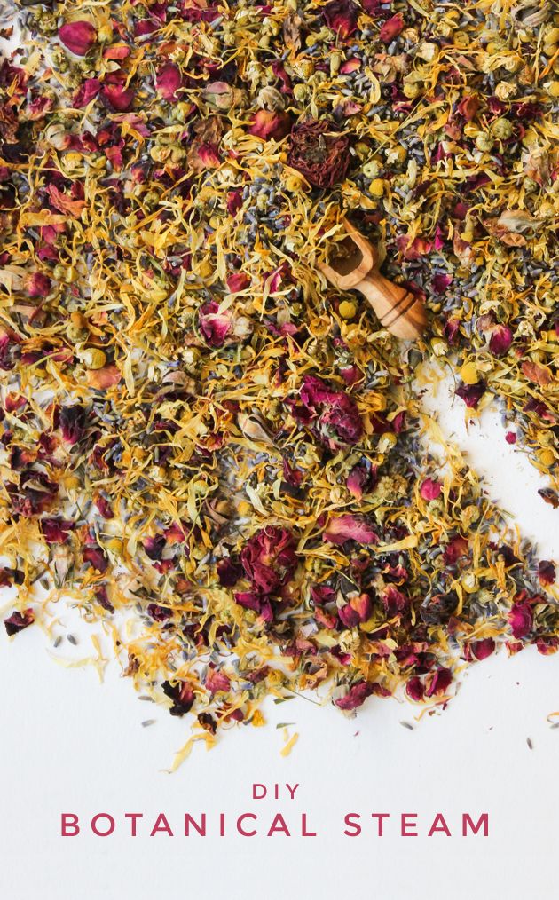 a pile of dried flowers next to a wooden spoon