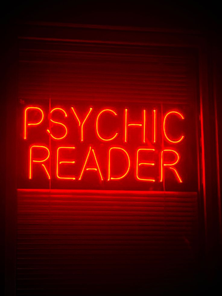 a red neon sign that says psychic reader