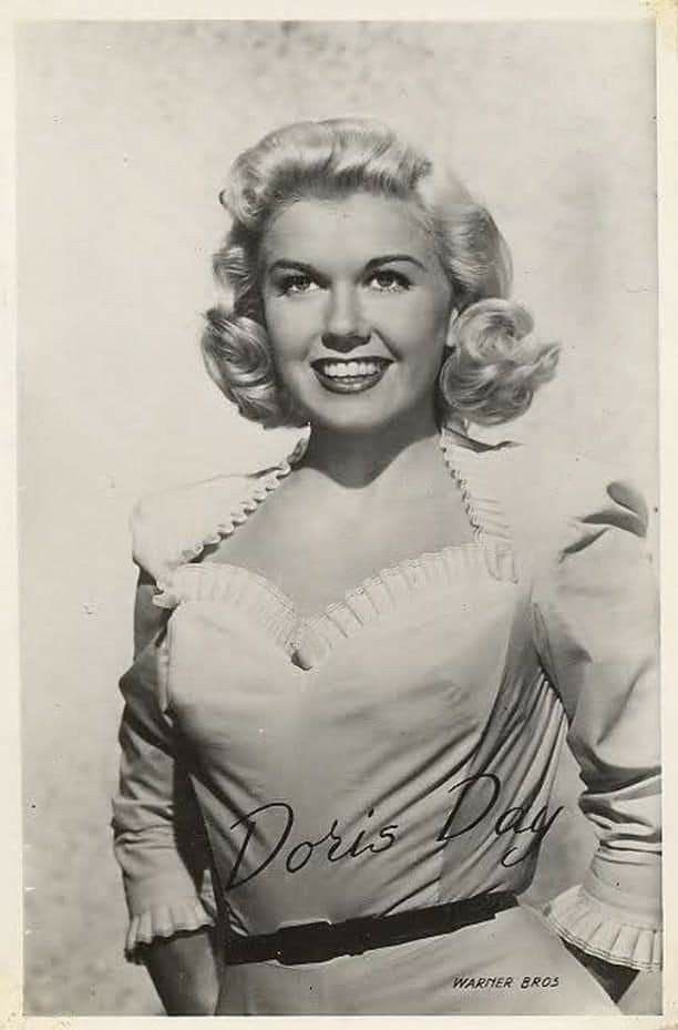 an old black and white photo of a woman with blonde hair wearing a top that says doris day