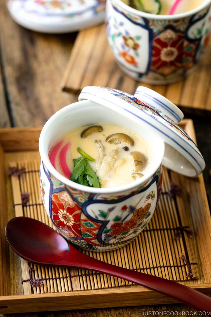 two bowls filled with soup on top of a wooden tray