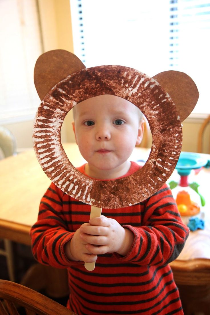 a young boy wearing a paper plate bear hat