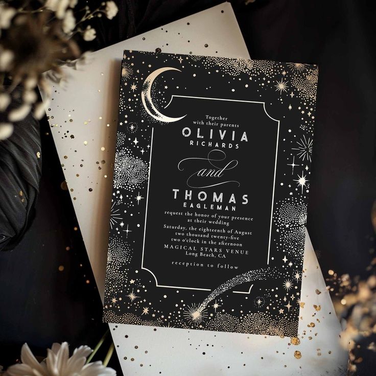 an elegant black and white wedding card with stars, moon and crescents on it