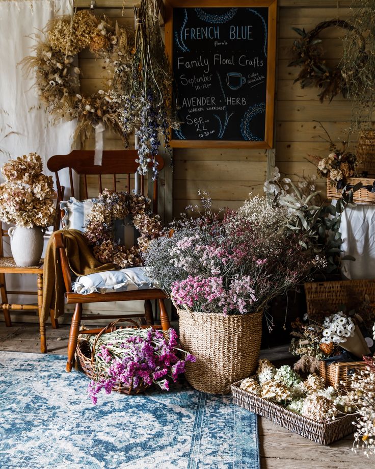 a room filled with lots of different types of flowers and plants in baskets on the floor