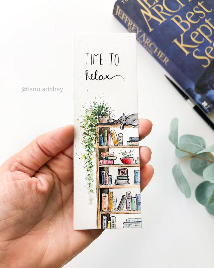 a hand holding up a bookmark that says time to relax with books in the background