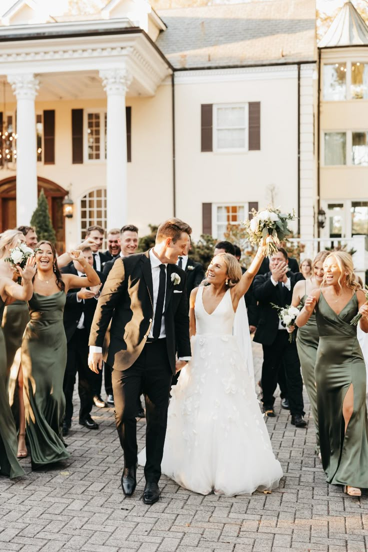 a bride and groom walk through the crowd as they exit their wedding ceremony with champagne in hand