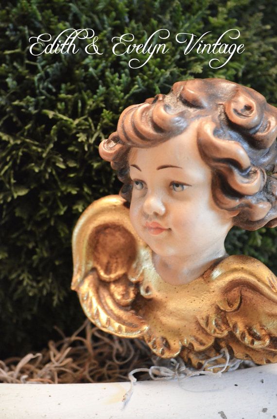 an antique figurine with curly hair is sitting in front of some bushes and shrubbery