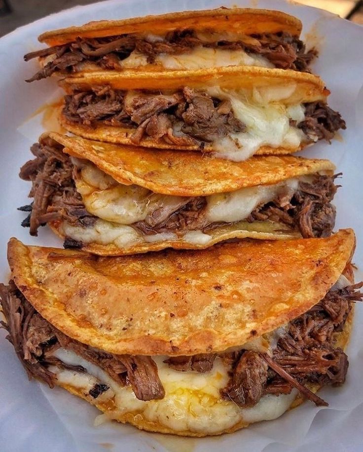 three tortillas stacked on top of each other with meat and cheese in them