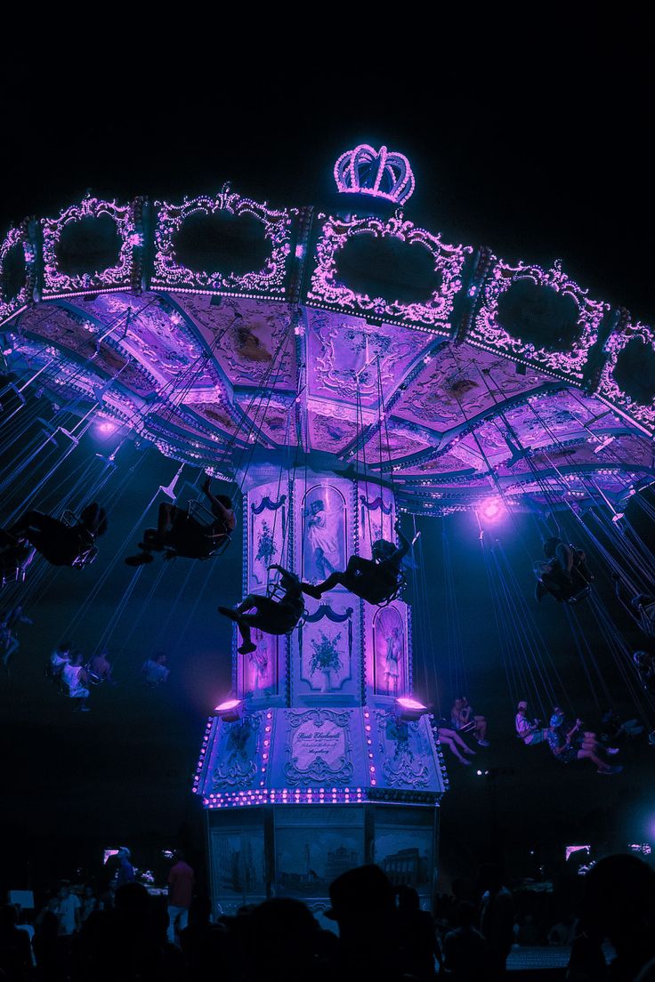 an illuminated merry go round ride at night