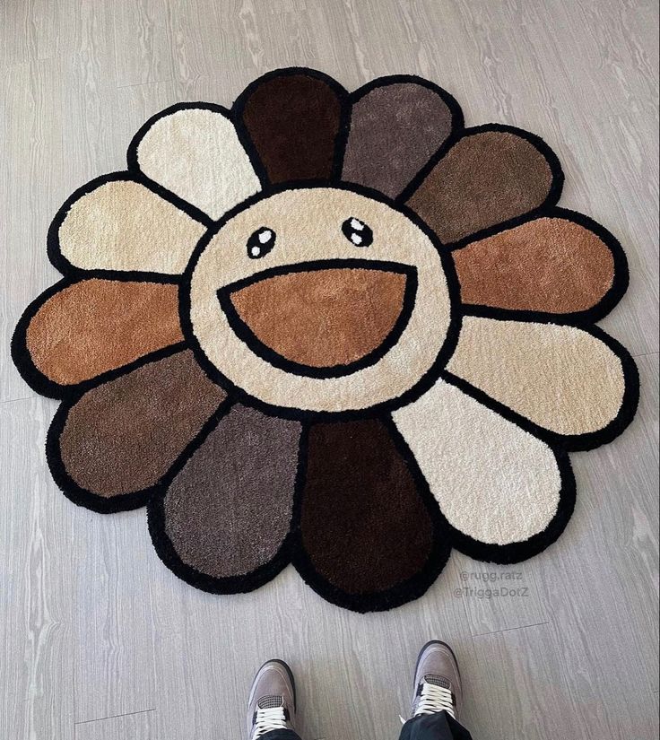 a person standing on the floor in front of a rug with a turkey face drawn on it