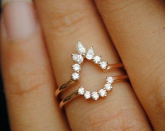 a woman's hand with a gold ring on it and diamond rings in the middle