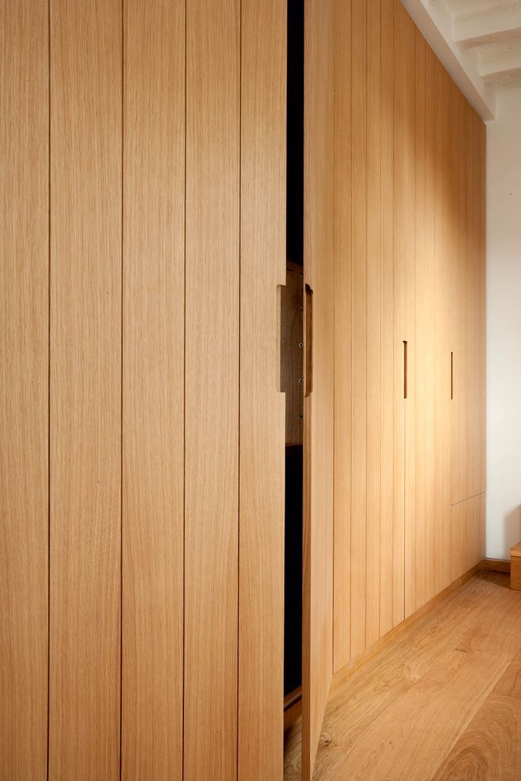 a bedroom with wooden closets and white walls