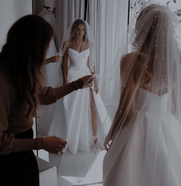 the bride is getting ready to walk down the aisle in her wedding dress and veil