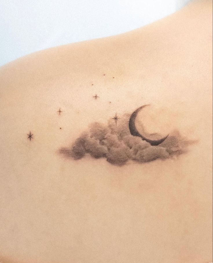 the back of a woman's stomach with a crescent and stars tattoo on it