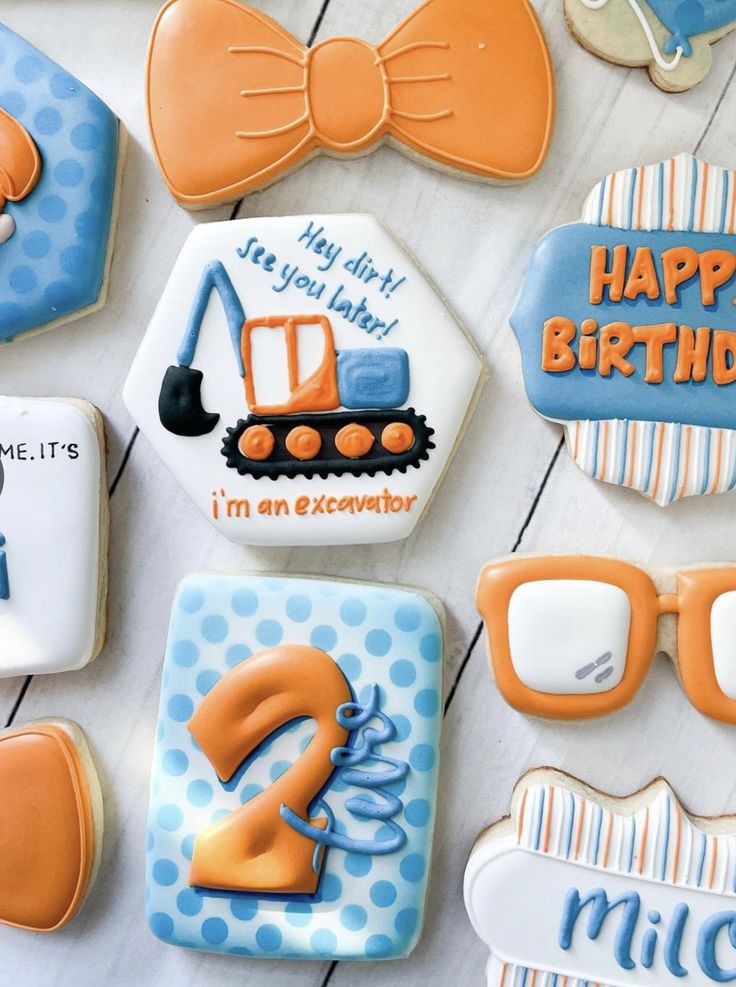 decorated cookies are arranged in the shape of tractors and construction equipment, with words that say happy birthday