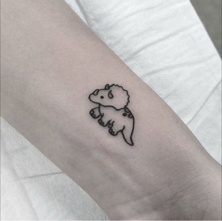 a small tattoo on the arm of a person with a bear in it's body