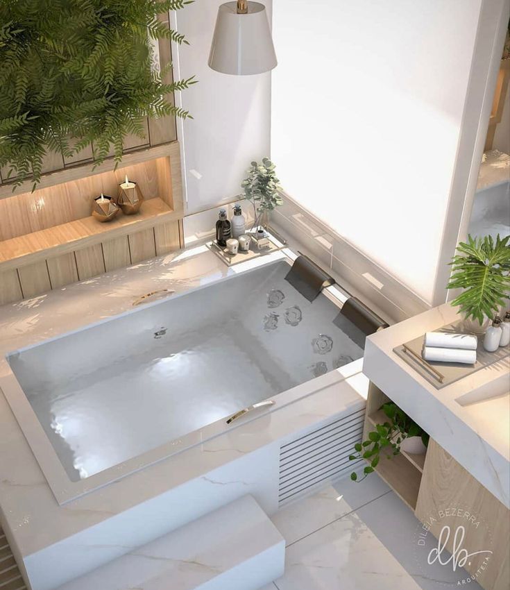 a bath tub sitting next to a sink in a bathroom under a light hanging above it