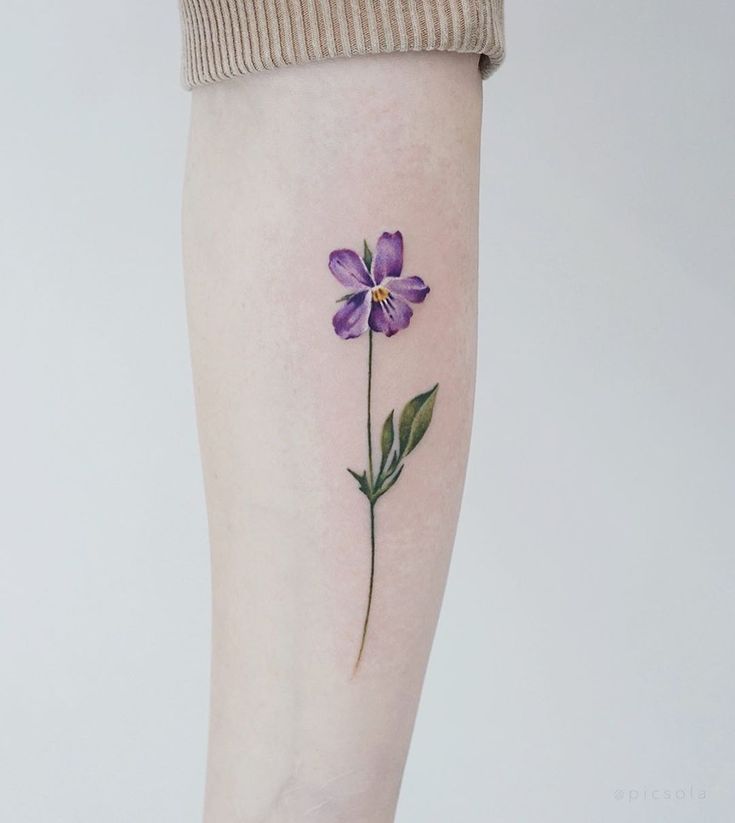 a small purple flower on the right thigh