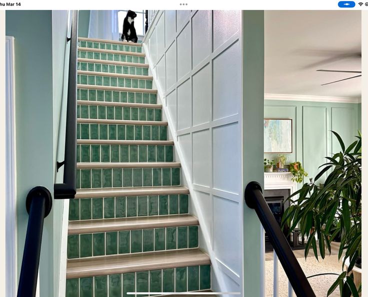 an image of stairs going up the side of a house with green glass tiles on them