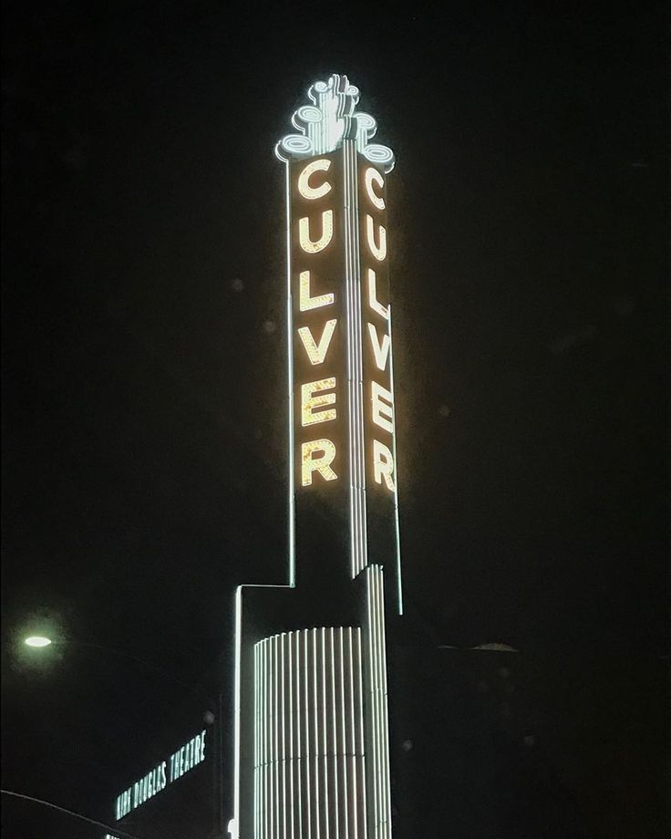 the culverver theater sign is lit up at night with lights on it's sides