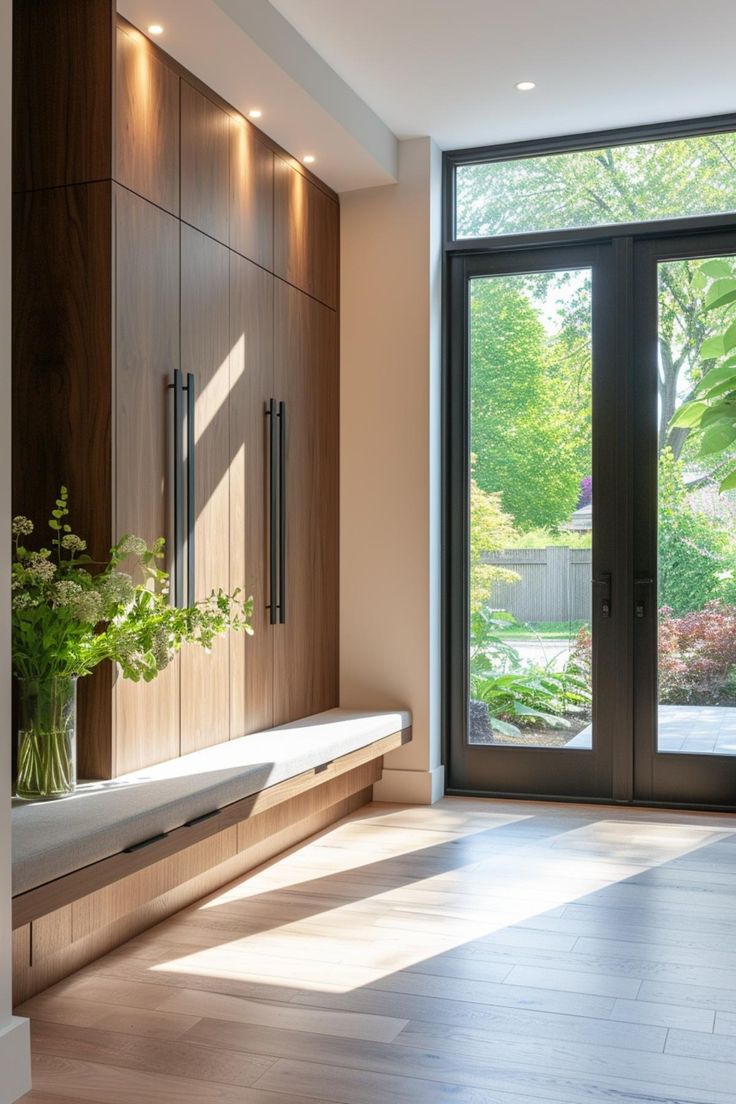 an empty room with large sliding glass doors and wood flooring, along with a planter filled with flowers