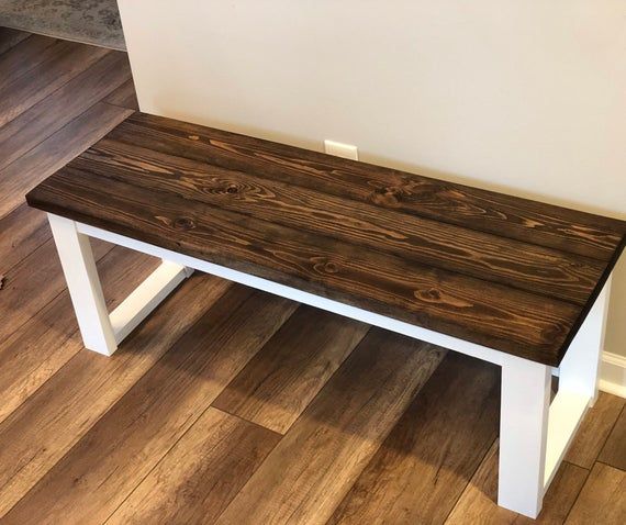 a wooden bench sitting on top of a hard wood floor