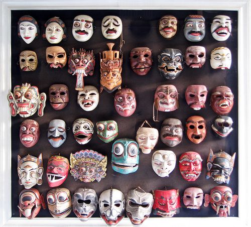 a group of masks on display in a white frame