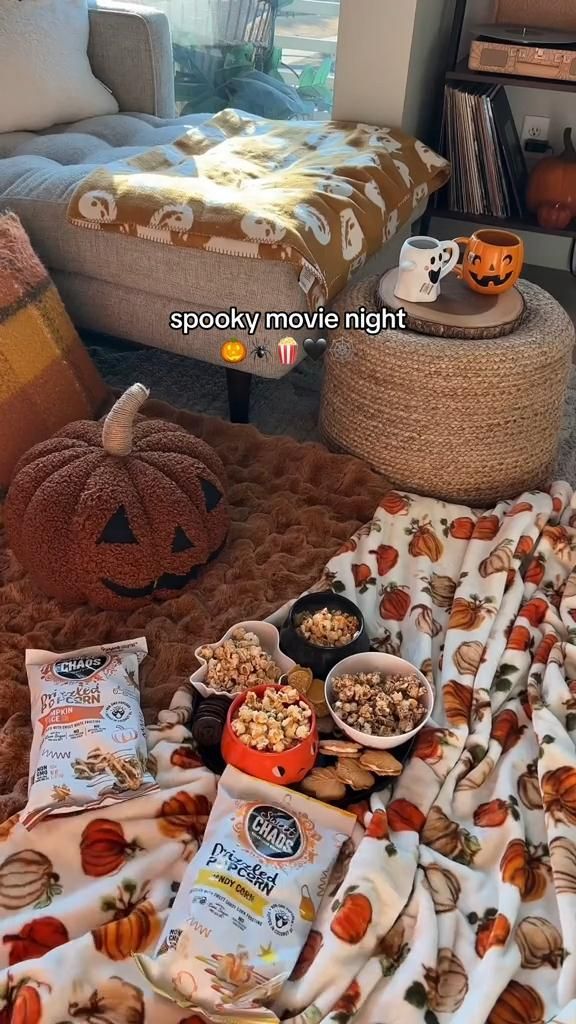 a living room filled with lots of pumpkins and snacks on top of a rug