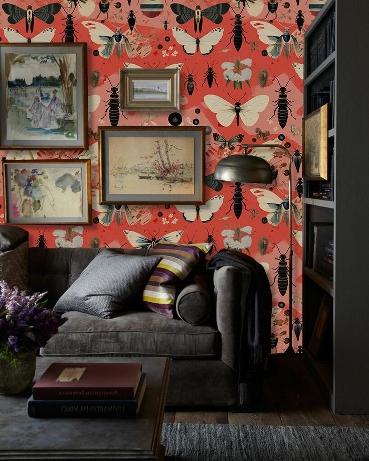 a living room filled with furniture and wallpaper covered in bugs on red walls next to a book shelf