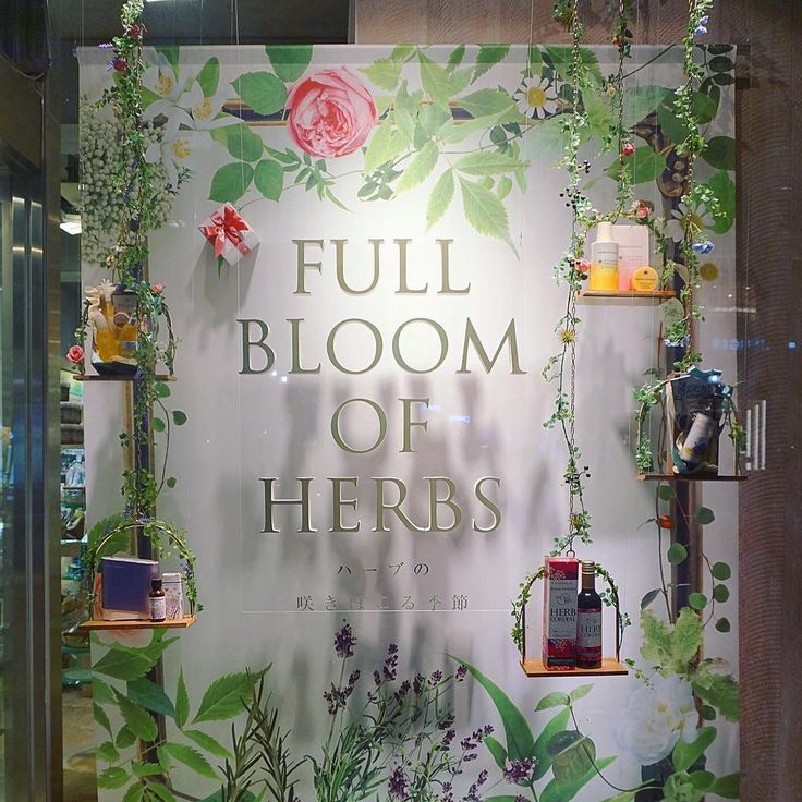 a display case with flowers and plants on it's sides that says full bloom of herbs