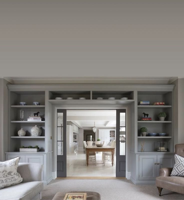 a living room filled with furniture and lots of shelves