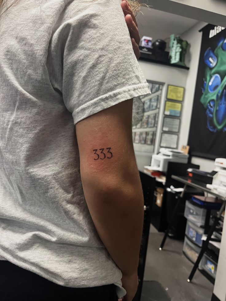 a woman with a small tattoo on her left upper arm and the number 533