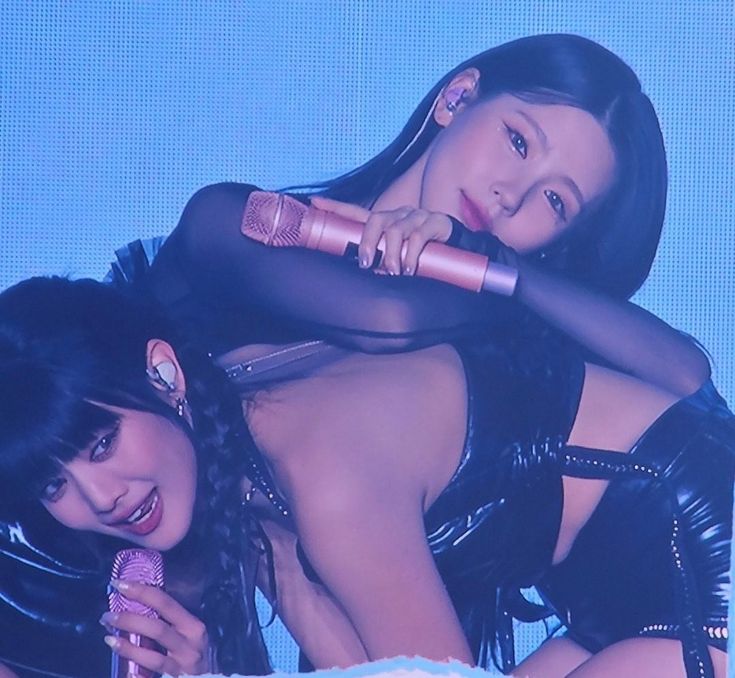 two women are posing for the camera on stage