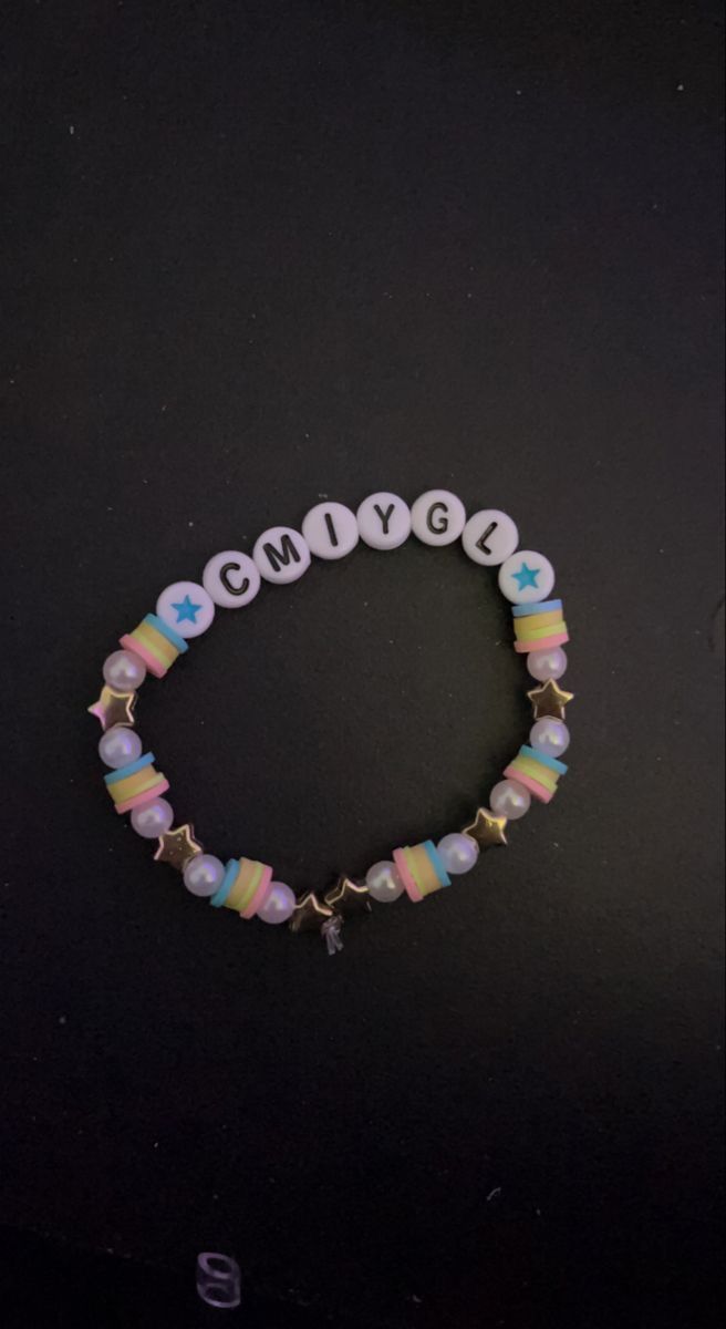 a beaded bracelet with the word comfy written in white and pink beads on a black background