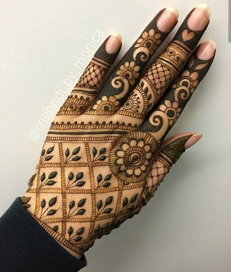 a woman's hand with henna tattoos on it