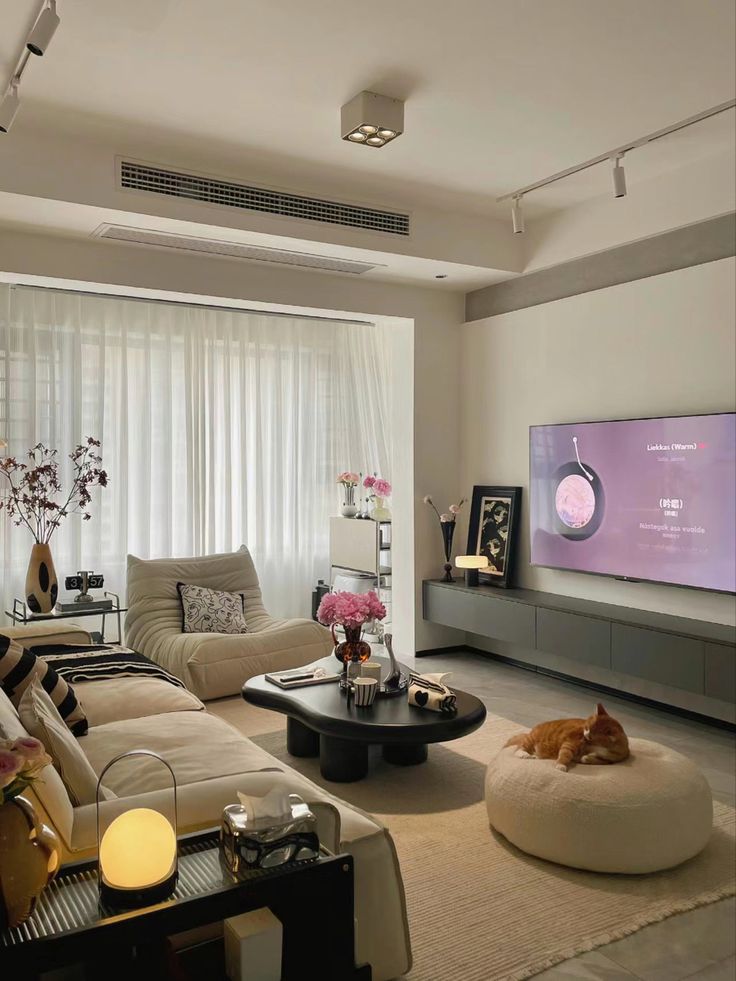 a living room filled with furniture and a flat screen tv mounted to the side of a wall