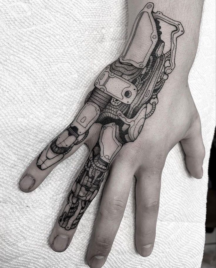 a black and white photo of a hand with a robot tattoo on it's arm