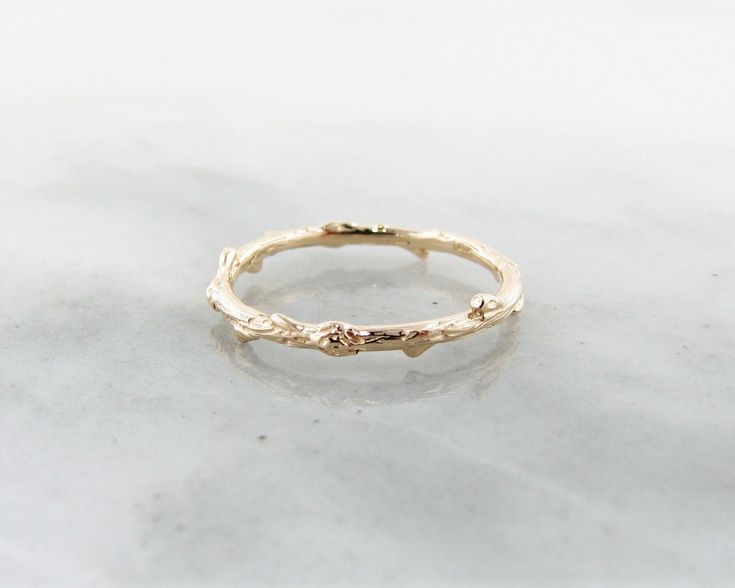 Solid Yellow Gold Ring, Slender Twig Band Available in Sizes 4-8 14k Rose Gold Rustic Signature Design Twig Band is a dainty little band that graces the hand with a touch of woodsy charm. This slender band is covered in bark-like texture and features knots and nubs that makes it resemble an actual slender branch wrapped around your finger. A unique wedding band idea, or even just a great accented stacking ring! This is a delicate addition to our rustic range of designs in 14K Yellow Gold. Weighs Twig Wedding Band, Gold Twigs, Twist Wedding Band, Unique Wedding Band, Woodland Jewelry, Twig Ring, Unique Wedding Bands, Jewelry Studio, Jewelry Lookbook