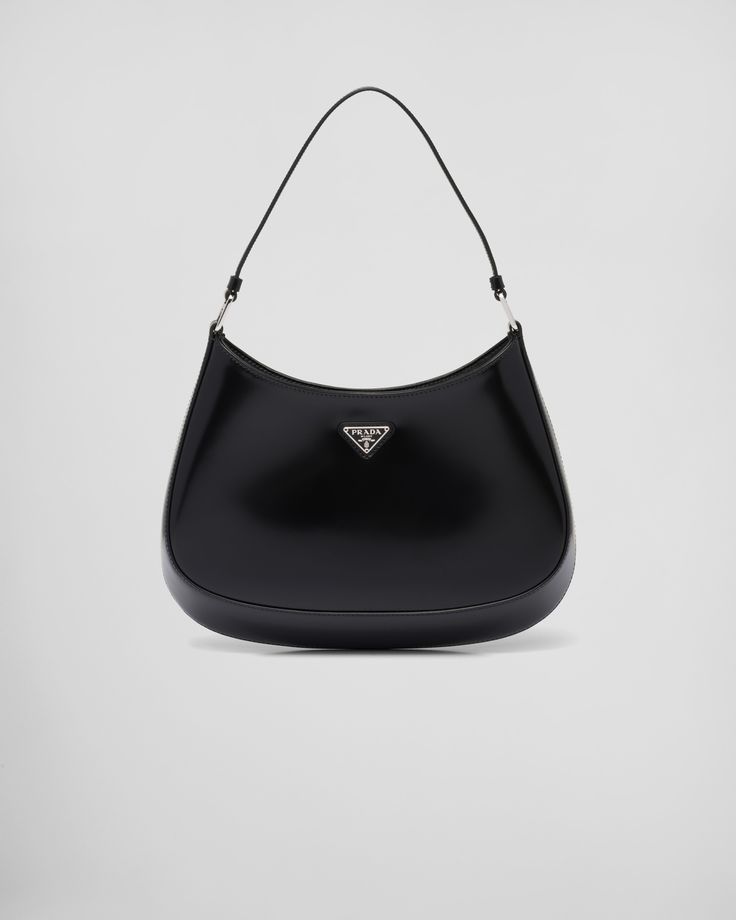 Brushed leather Leather handle Metal hardware Logo on enameled metal triangle at the front Magnet closure Prada logo nylon lining with patch pocket Black Prada Bag, Prada Cleo, Prada Purses, Prada Collection, Prada Shoulder Bag, Prada Logo, Prada Leather, Black Shoulder Bag, Black Bag