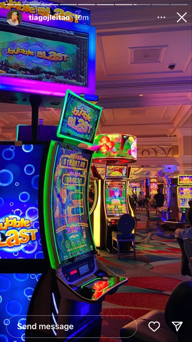 several slot machines in a casino with neon lights