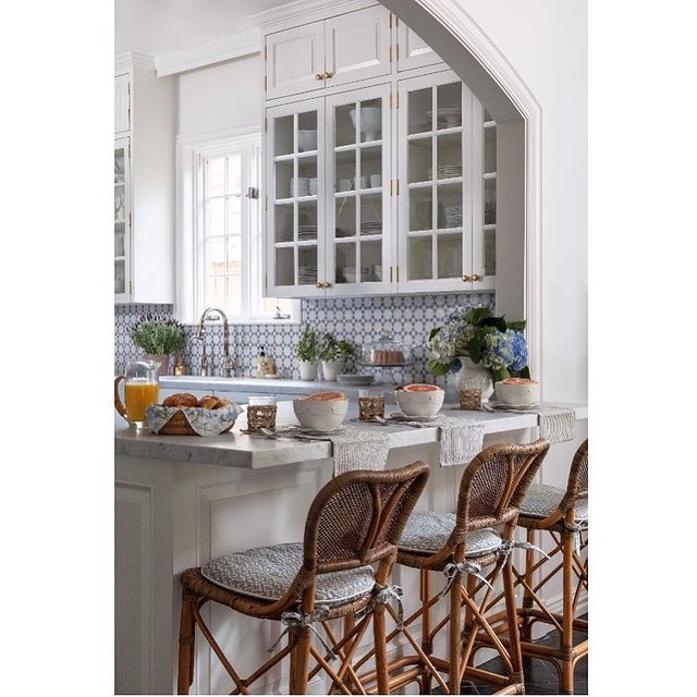 a kitchen filled with lots of counter top space and white cabinets next to a breakfast bar