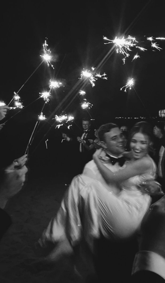 the bride and groom are surrounded by sparklers