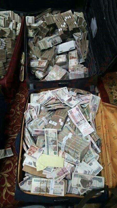 two suitcases filled with money sitting on top of a floor next to each other