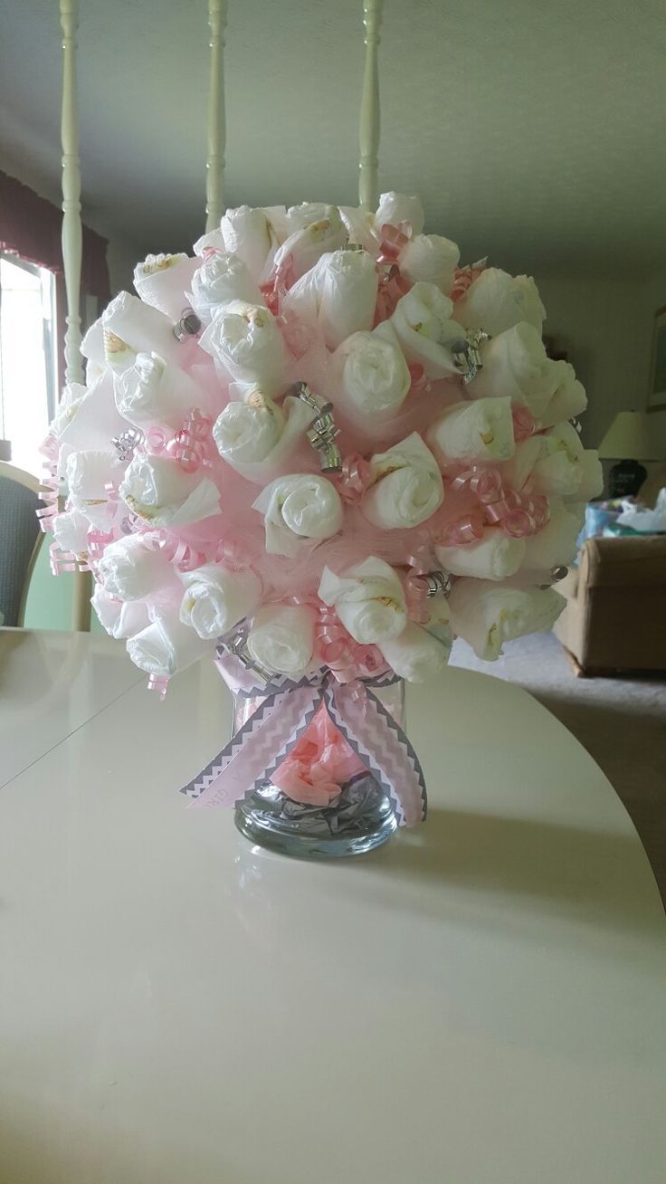 a bouquet of white and pink flowers sitting on top of a table in front of a window