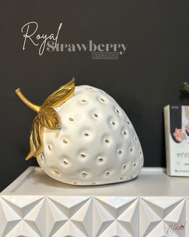 a white ceramic strawberry sitting on top of a table